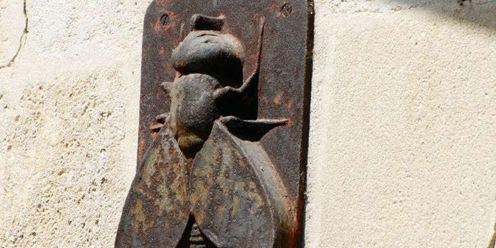 mouche en bas-relief de bronze à l'entrée de l'usine du Docteur Moure